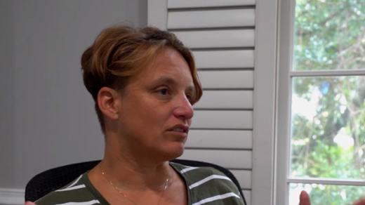 Megan talking in an office.